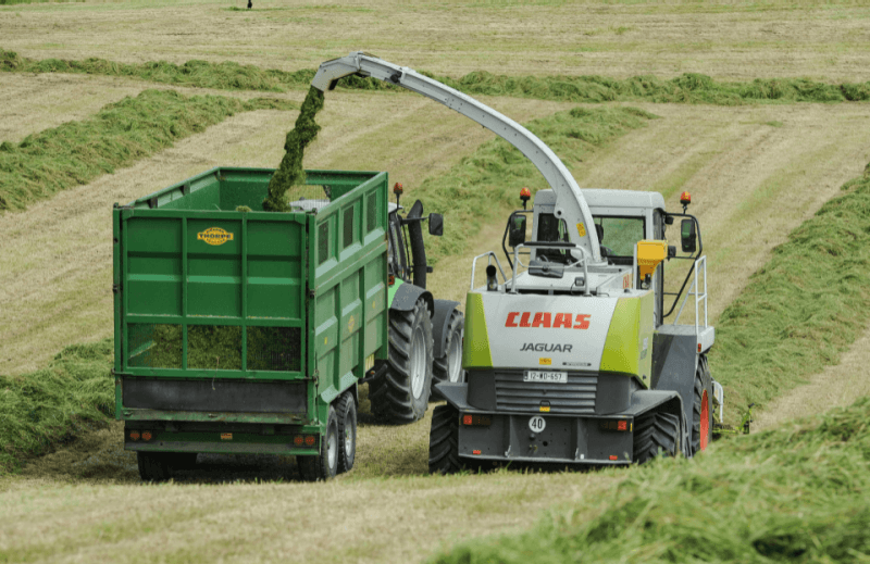 combine filling a trailer while harvesting